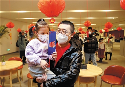 图为市民带孩子一起参加猜灯谜活动。韩堃摄