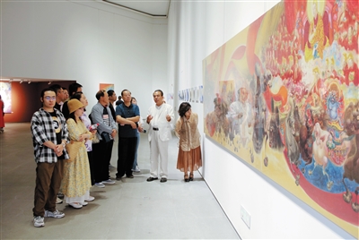 《一录梵花》李寅虎个人画展作者向观展嘉宾介绍展出画作。韩堃 摄