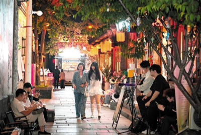 盛夏时节，大同古城东南邑历史文化街区，吉他浅唱低徊，非遗工坊灯火通明，游客漫步其间享受慢时光，感受传统文化气息。资料照片