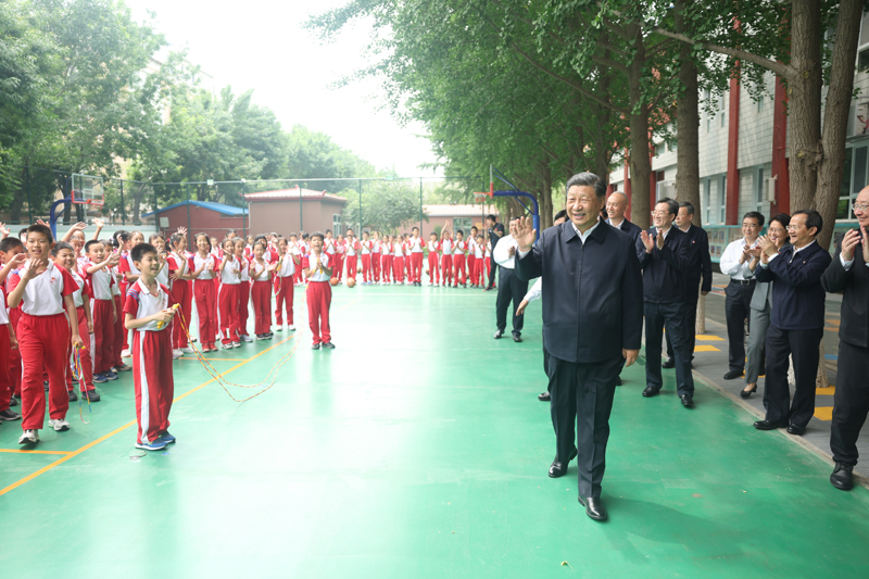 5月31日上午，中共中央总书记、国家主席、中央军委主席习近平来到北京育英学校看望慰问师生，向全国广大少年儿童祝贺“六一”国际儿童节快乐。这是习近平在篮球场向正在上体育课的小学生们挥手致意。新华社记者 鞠鹏 摄