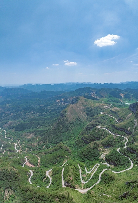 左权县境内太行山山路形似游龙，在绿林间蜿蜒。张文军摄