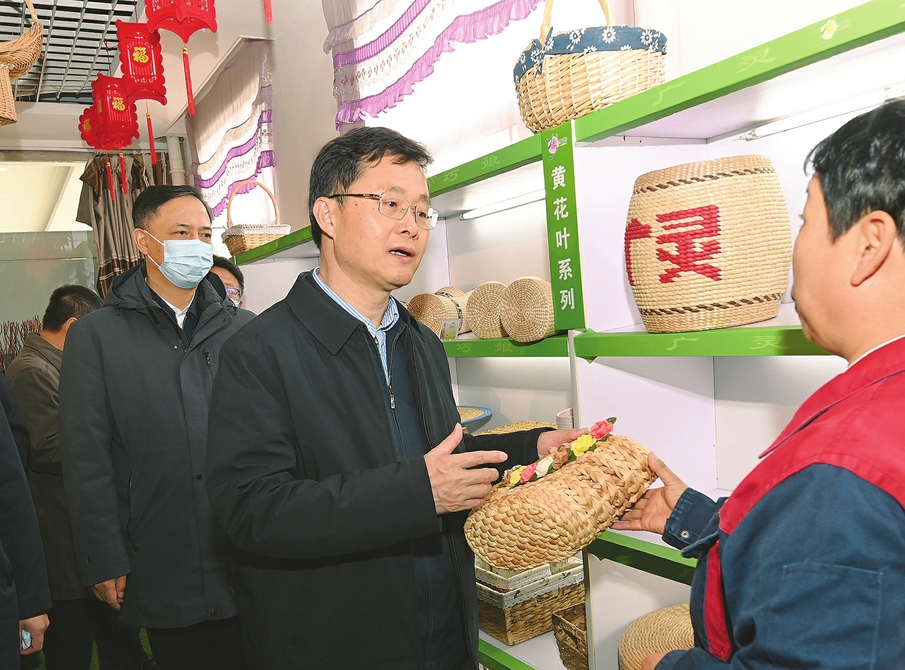 四月二十四日，省委书记蓝佛安在广灵县巧娘宫科技公司饶有兴致地一 一察看各类杞柳、蒲草、黄花叶、玉米皮编织品。 史晓波摄