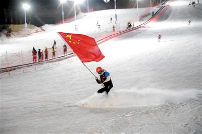卧龙山滑雪场启动运营仪式上，滑雪教练手持红旗从山坡滑下。 图片由马军营街道提供