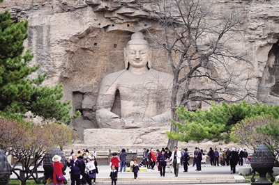 游客在山西大同云冈石窟游览（2021年5月9日摄）。　新华社记者　詹彦摄