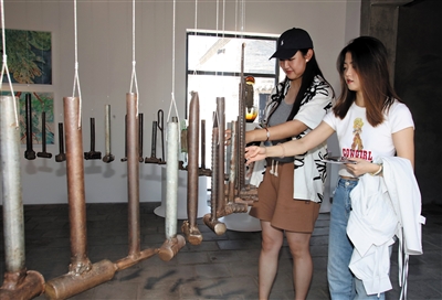 图为参观者在展出现场感受艺术的奇妙。韩堃摄