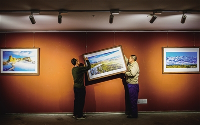 首届全国“情暖冬季镜美大同”摄影展今日上午在市美术馆开幕。图为昨日布展人员正在调校展品。张占兵 摄