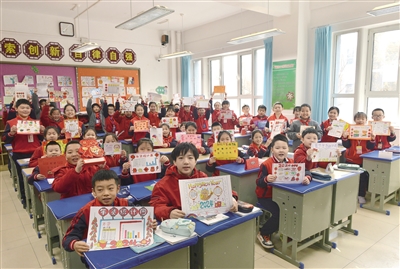 图为平城区45校四年级2班的学生展示寒假期间制作的手抄报。戎禹仁摄