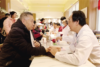 图为医生正在为社区居民把脉问诊。韩堃摄