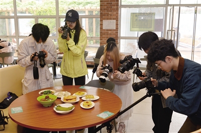 4月23日，在同济大学西苑饮食广场餐厅，同济学子们拍摄、记录大同传统特色美食。戎禹仁摄