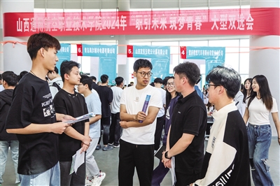图为学校老师现场为学生进行就业指导。韩堃摄