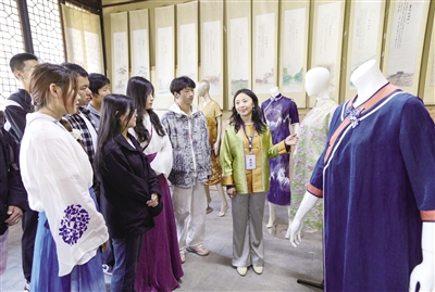 图为在华服展示区，大同大学教师向市民游客介绍传统服饰。韩堃摄