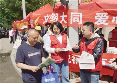 昨日，一年一度的高考如期而至，莘莘学子迎来了人生重要时刻。图为考点外大同日报社“爱心送考”志愿者向考生家长赠送《大同晚报》。戎禹仁摄