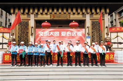活动现场，为参与“爱心送考”的出租车驾驶员送上绿丝带及车贴。韩堃 戎禹仁摄