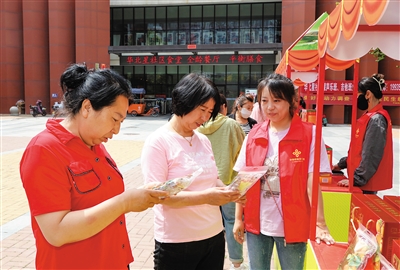 图为社区居民正在挑选黄花产品。韩堃摄