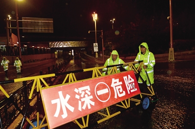 8月26日凌晨，市城市管理综合行政执法支队工作人员在雨中坚守。李冬宾摄