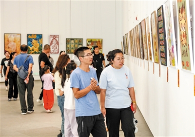图为市民游客正在观看李丹阳文创插画艺术展。韩堃摄