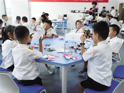 参加研学营活动的孩子们动手研究无人机的构成与组装，激发出对航空的好奇心与探索欲望。闫昌摄