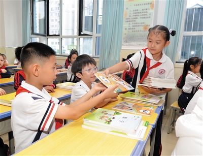 图为平城区四十五校学生正在发放新学期课本。戎禹仁摄