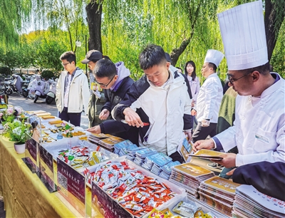 图为清华学子品尝大同特色小吃。戎禹仁摄