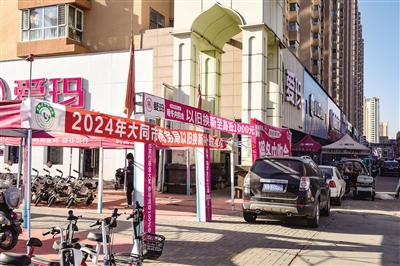 图为东信电动自行车一条街上以旧换新政策宣传横幅很醒目。韩堃摄