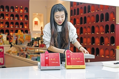 图为市雕塑博物馆文创店工作人员正在将《字见大同2025》文创台历摆上精品文创销售展台。于宏摄