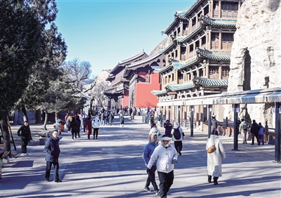 12月24日，游客在云冈石窟游览。入冬后，尽管天寒地冻冷意袭身，但世界文化遗产云冈石窟每天都有众多的外地游客前来参观游览，欣赏这一艺术瑰宝，亲身感受石窟艺术魅力以及大同厚重的历史文化底蕴。张燕伟摄