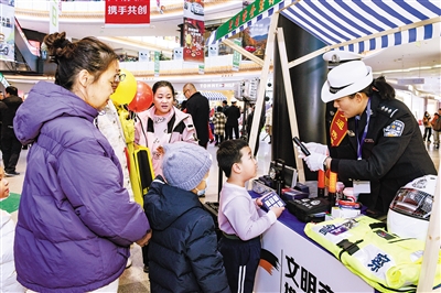 图为活动现场交警向小朋友介绍警用装备。韩堃摄