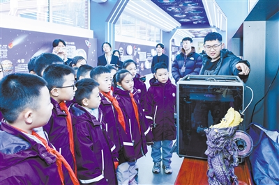 图为该校学生观看3D打印过程。韩堃摄