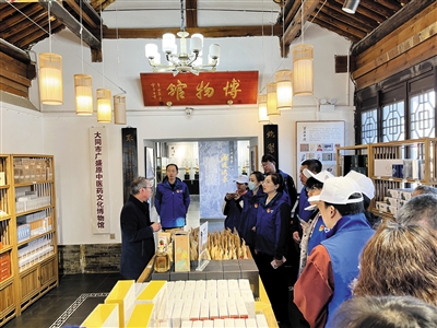 图为志愿者在广盛原中医药文化博物馆聆听工作人员讲解，感受传统文化魅力。锦秀摄