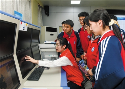 图为工作人员向学生讲解气象云图。戎禹仁摄