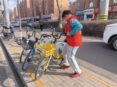 图为平城区14校学生走上街头摆放共享单车。戎禹仁摄
