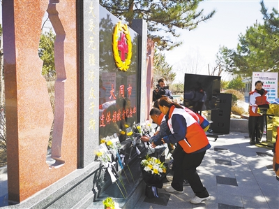 图为在缅怀纪念活动现场，参加活动人员向遗体捐献者纪念碑献花。高燕摄