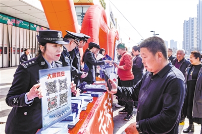 图为公安民警向市民宣传总体国家安全观和国家安全法律法规。韩堃摄