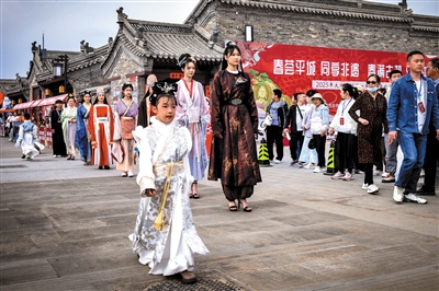 右下图为“五一”假期在大同古城柴市角上演的“北魏服饰展演”。韩堃摄