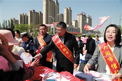 图为市信访局工作人员发放《信访工作条例》宣传资料。丰曼摄