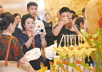 7月22日，2025黄花产业发展大会召开。图为与会嘉宾在会议现场展示区观看黄花文创产品。张燕伟摄