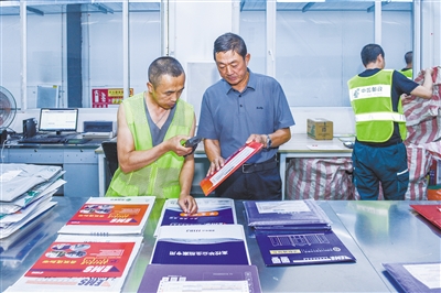 图为邮政工作人员正在分拣高考录取通知书。韩堃摄