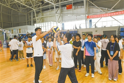 图为教练员指导学生训练排球基本动作。戎禹仁摄