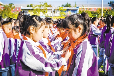 图为市实验小学少年先锋队老队员代表为新队员佩戴鲜艳的红领巾。韩堃摄