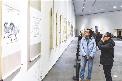 图为观展者欣赏以骏马奔腾为主题的武华兴画作。韩堃摄