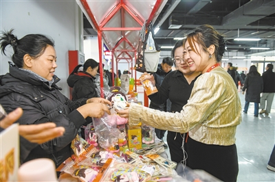 图为东风里数据服务基地职工在各展位间试吃、询价。于宏摄