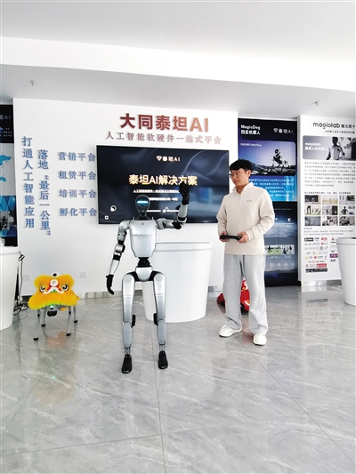 在泰坦智桥科技有限公司展台前，技术人员正调试银色人形机器人。闫昌摄