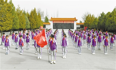 图为少先队员向革命烈士纪念塔敬献花篮并鞠躬默哀。于宏摄