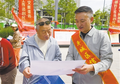 图为工作人员向市民讲解信访法治知识。戎禹仁摄