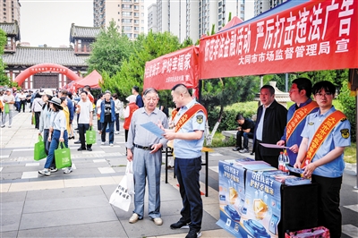 图为工作人员向市民讲解防诈知识。韩堃摄