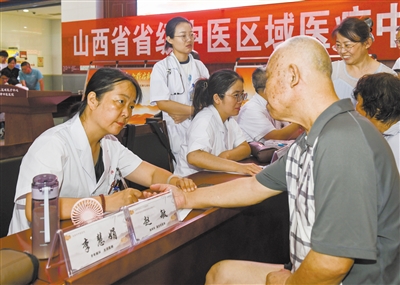 图为医生为市民把脉。戎禹仁摄 图为医生为市民把脉。戎禹仁摄