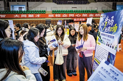 图为大同大学学生在招聘会现场咨询相关就业政策。韩堃摄
