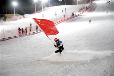 卧龙山滑雪场启动运营仪式上，滑雪教练手持红旗从山坡滑下。　图片由马军营街道提供
