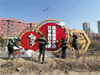 图为绿化队工作人员对绿化带内公益广告牌进行全覆盖式清洗。曹飞摄