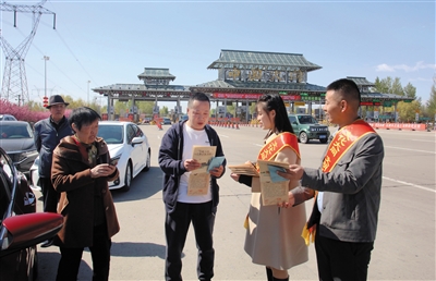 图为在御河西路南高速口，平城区14校教师向来同游客介绍大同旅游景点及地方美食。韩堃摄